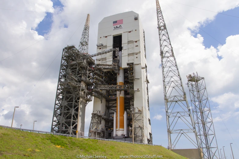 a space shuttle sits parked on a green hill