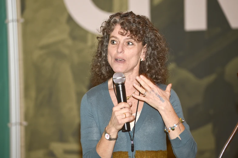 a woman is holding a microphone while talking