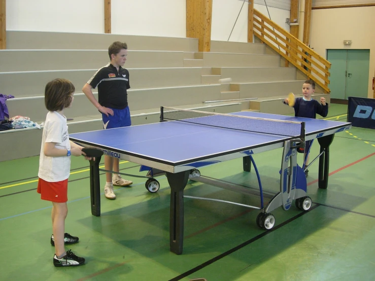 the s are playing ping pong in the gym