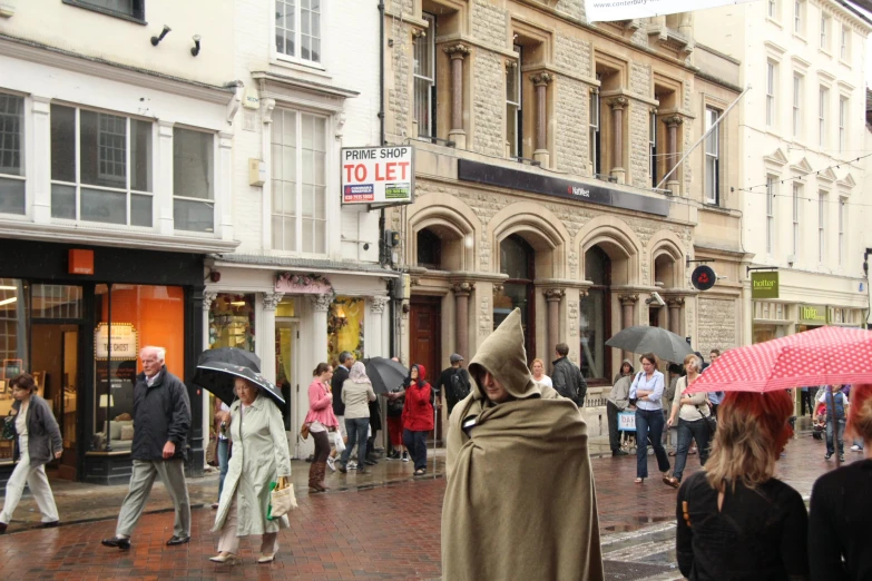 there are many people in the street walking and holding umbrellas