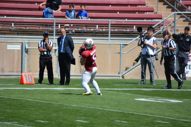 two football players are playing on the field while some fans watch