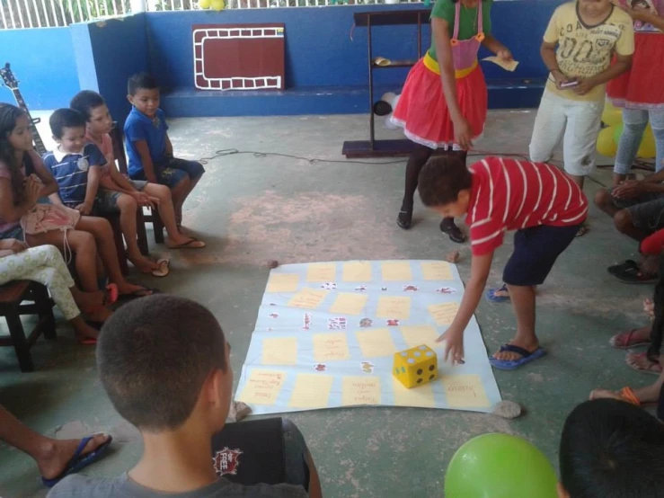 a group of young children playing a game on an inflatable sheet
