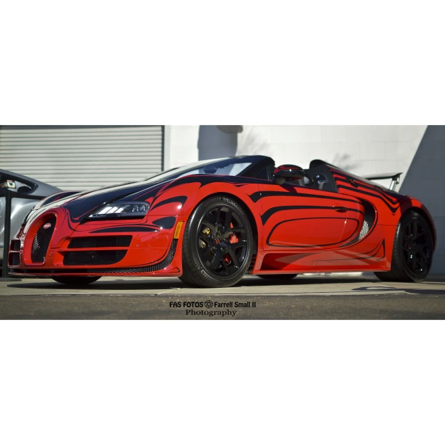 an orange sports car with black wheels and a red stripe on it