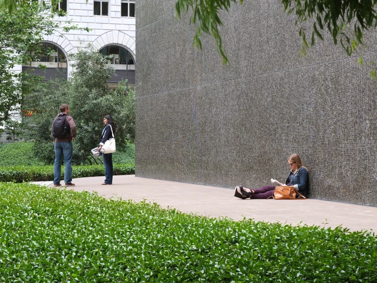 people are walking and sitting on the curb near the water