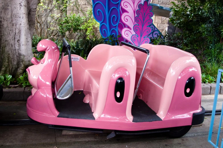 pink and black bumper car on a sidewalk