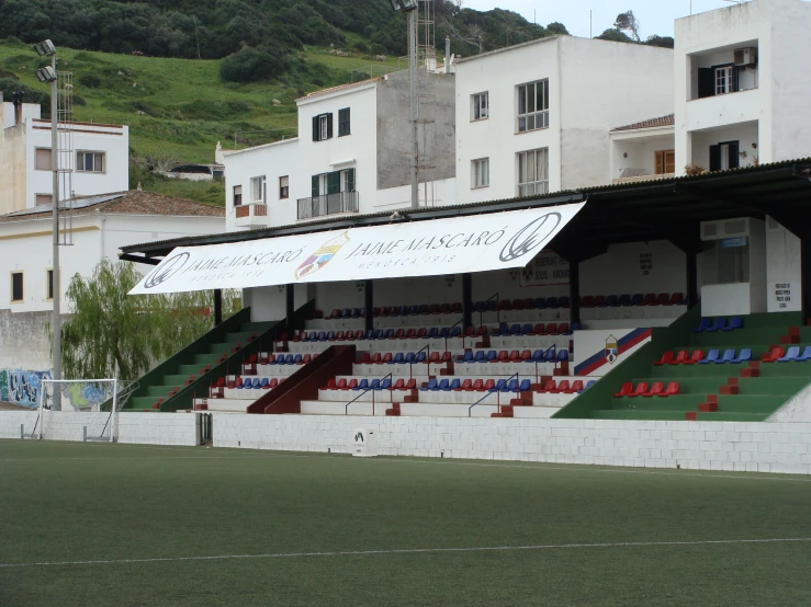 a baseball field with many chairs and an umbrella