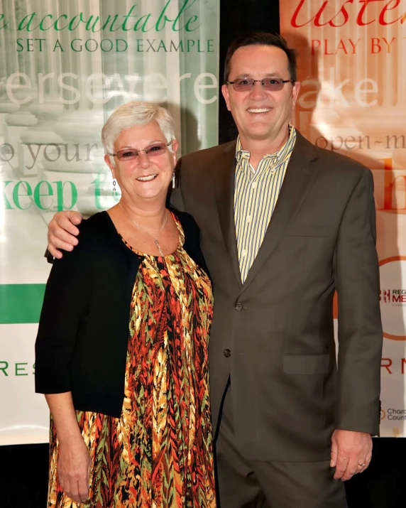 a man and woman pose for the camera on the red carpet