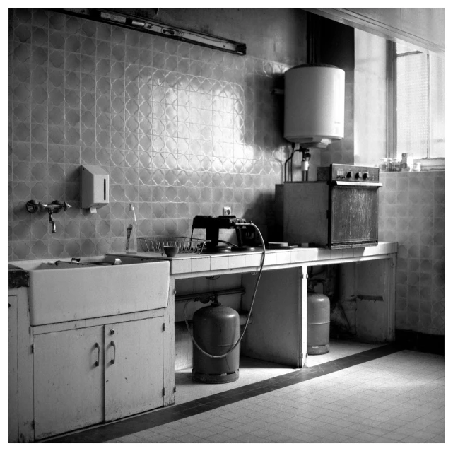 black and white pograph of a sink and a refrigerator