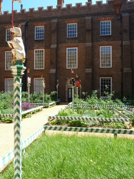 an elaborately designed garden and landscaping in front of a brick building