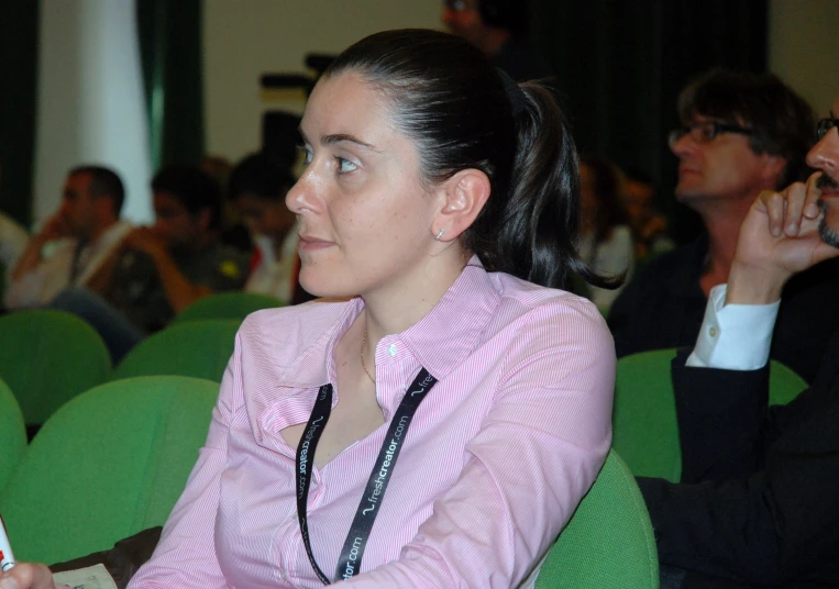 woman in pink and white striped shirt using her cell phone