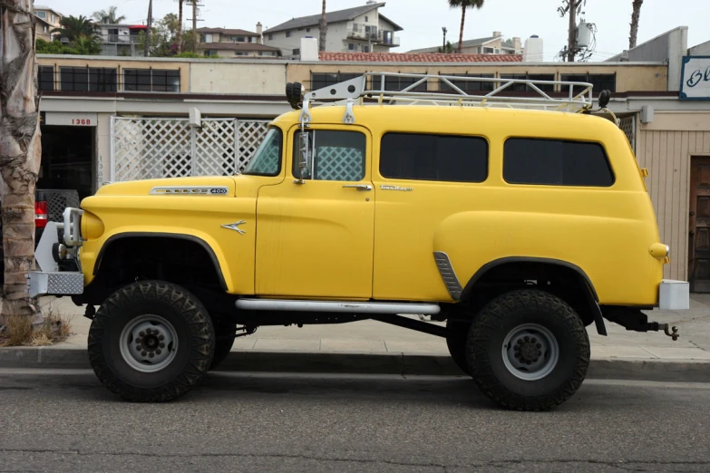 a bright yellow pick up truck is parked outside