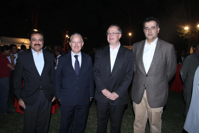 four men posing for a po at a formal function