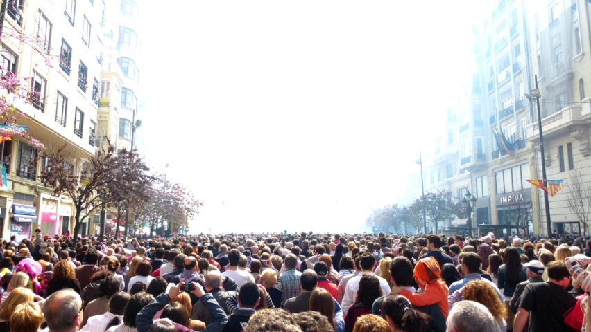 many people crowd around in the city streets