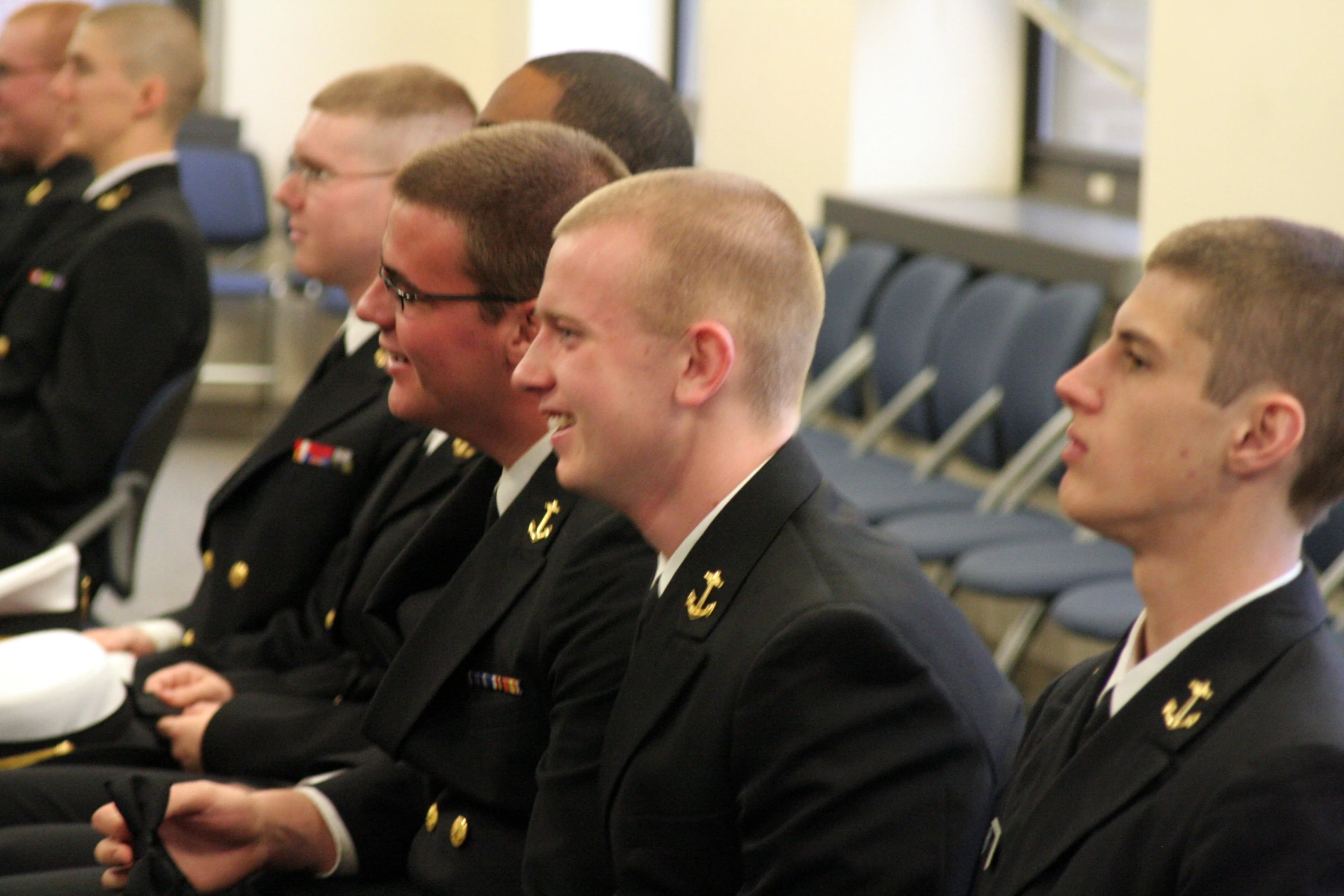 there are many uniformed men and women sitting in a row