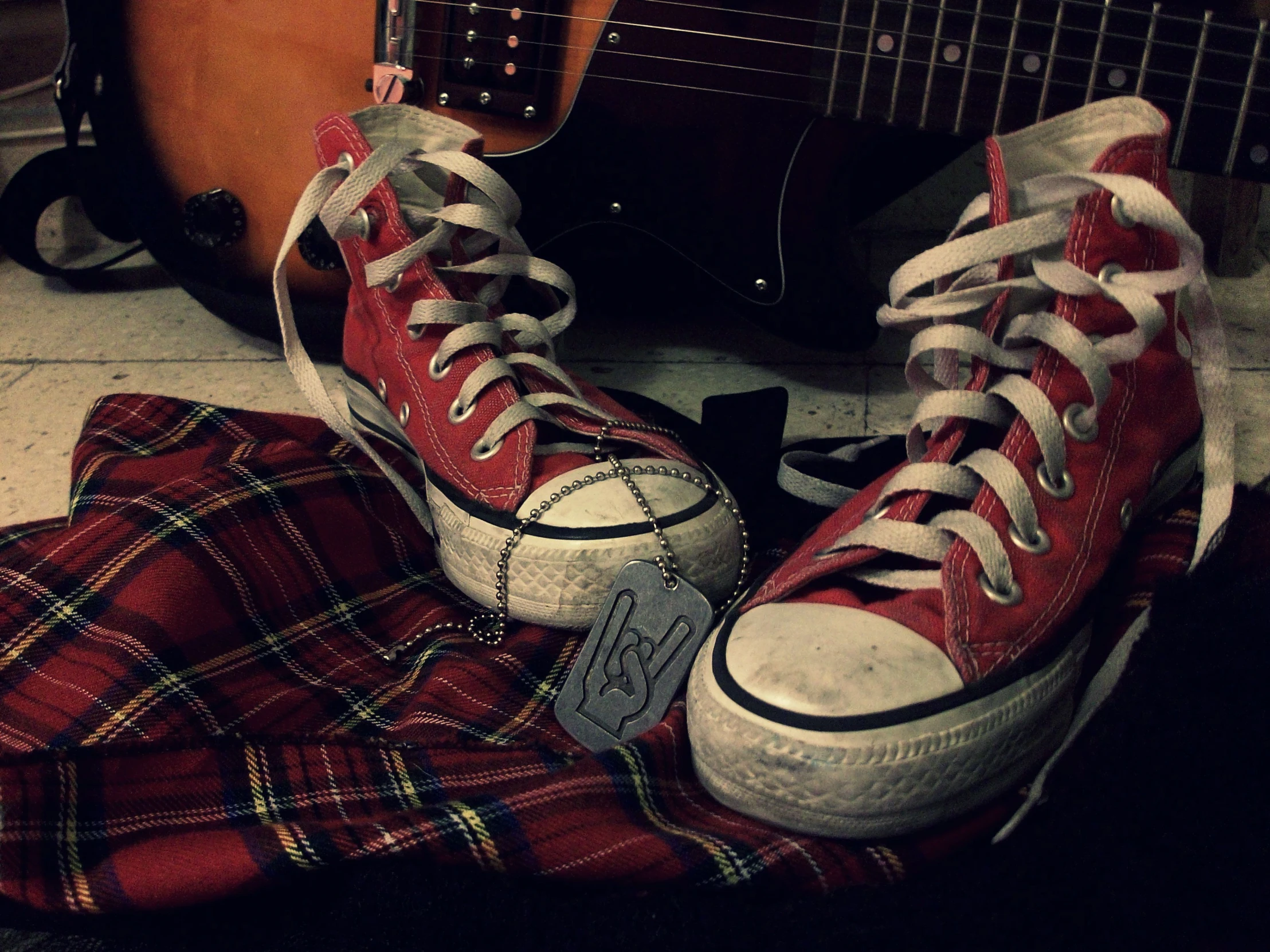 a pair of red sneakers and a brown guitar