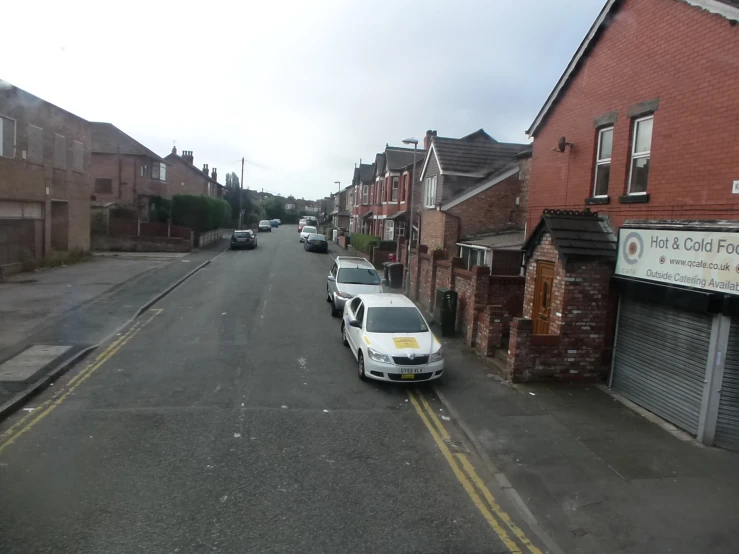 two cars parked on the side of the road in front of an old brick building