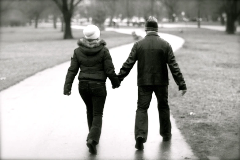 a couple walking down a path holding hands