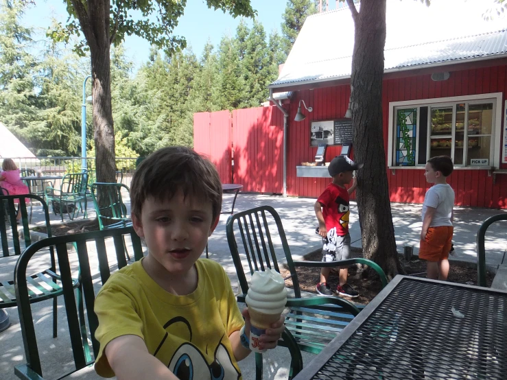 a little boy holding a vanilla ice cream in his hands