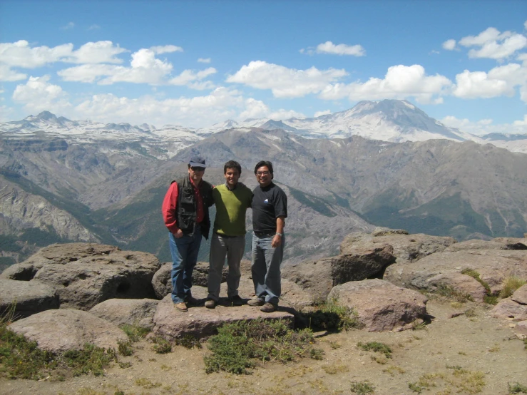 a group of men standing on top of a mountain