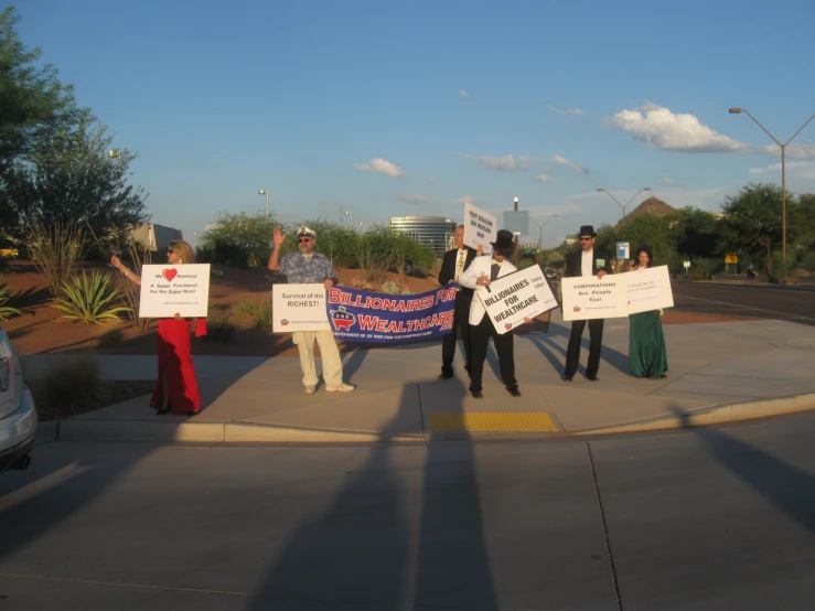 group of people holding signs standing outside on the street