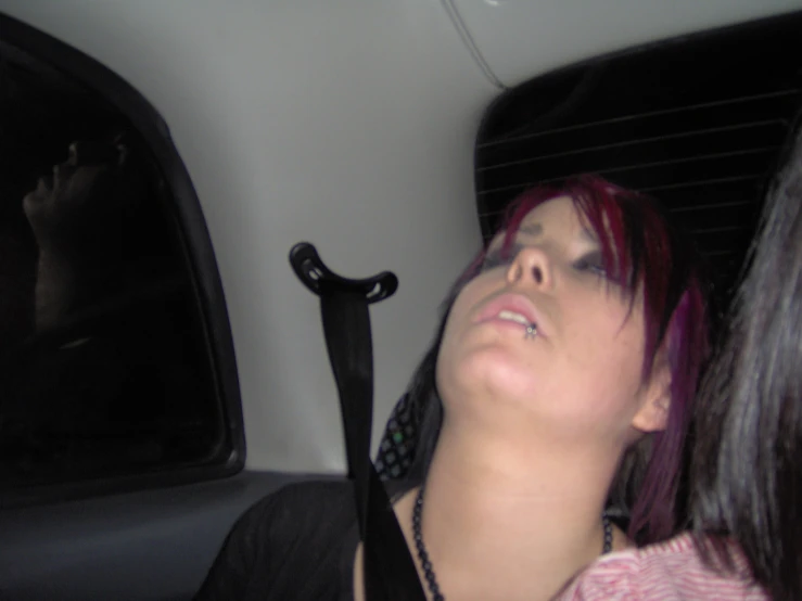 a woman laying her head in the back seat