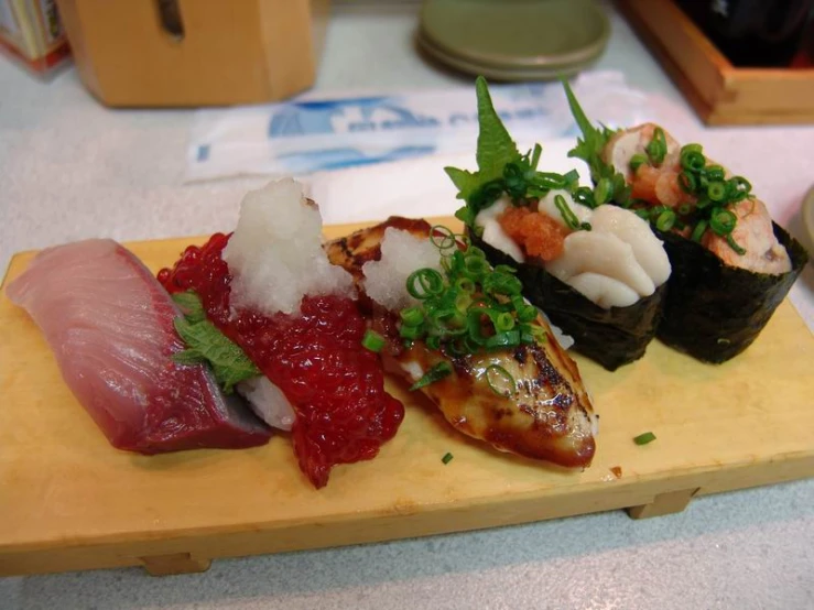 a variety of sushi on a board on the table