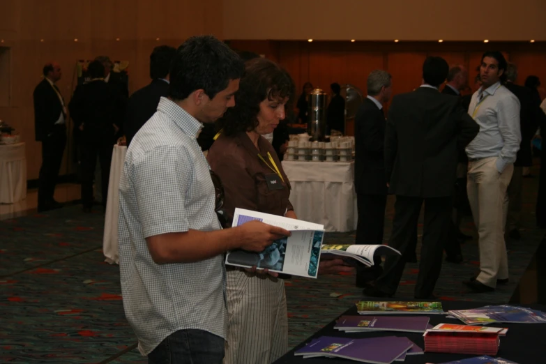 a man and woman are standing in front of a table with various folders