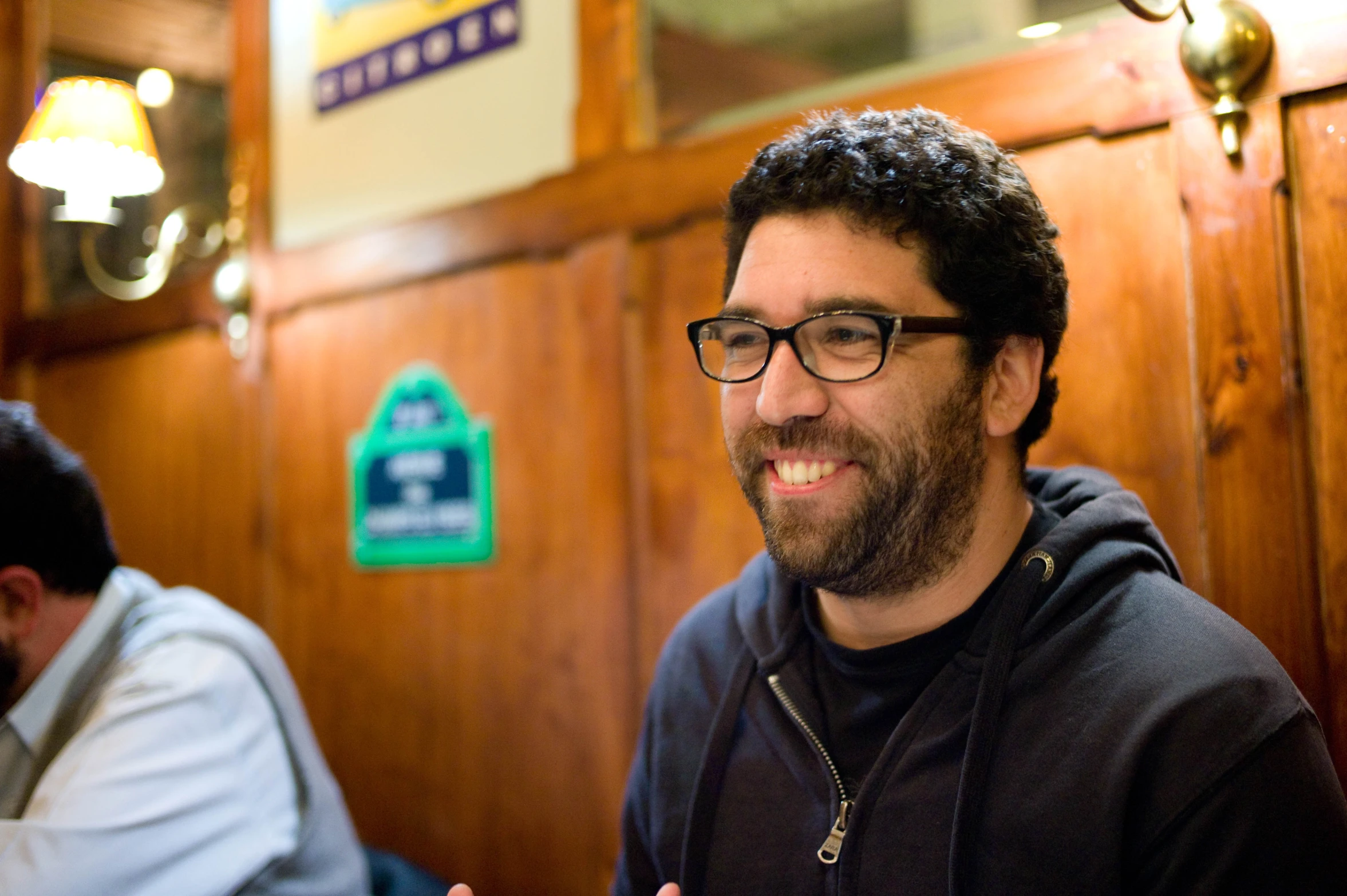 man in a restaurant laughing and giving the finger sign