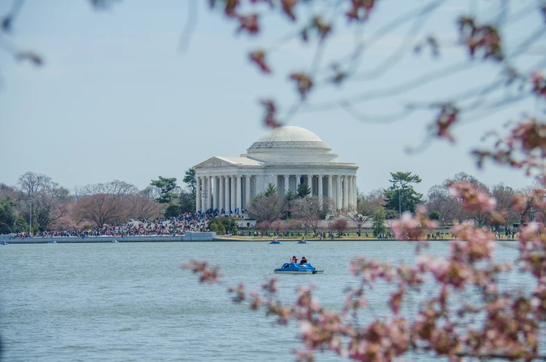 a man on a boat in the water near the lincoln memorial