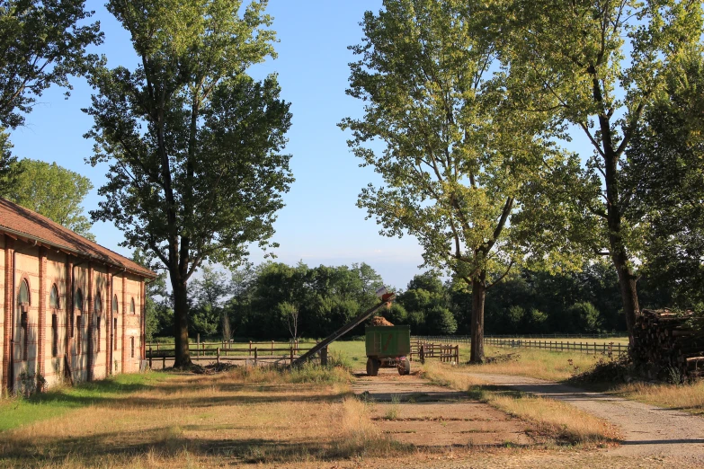 a man standing next to a barn near some trees