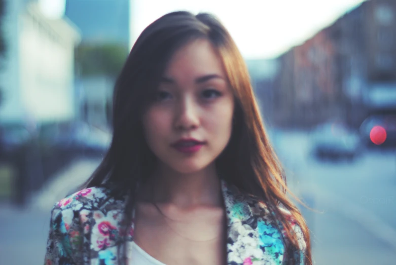 a woman standing on the street with a white shirt and jacket on