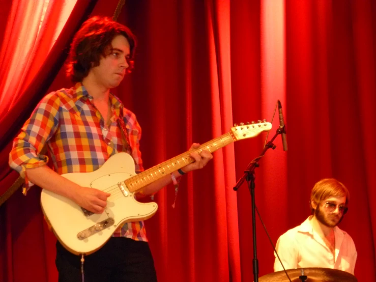 a person playing a music instrument in front of a microphone