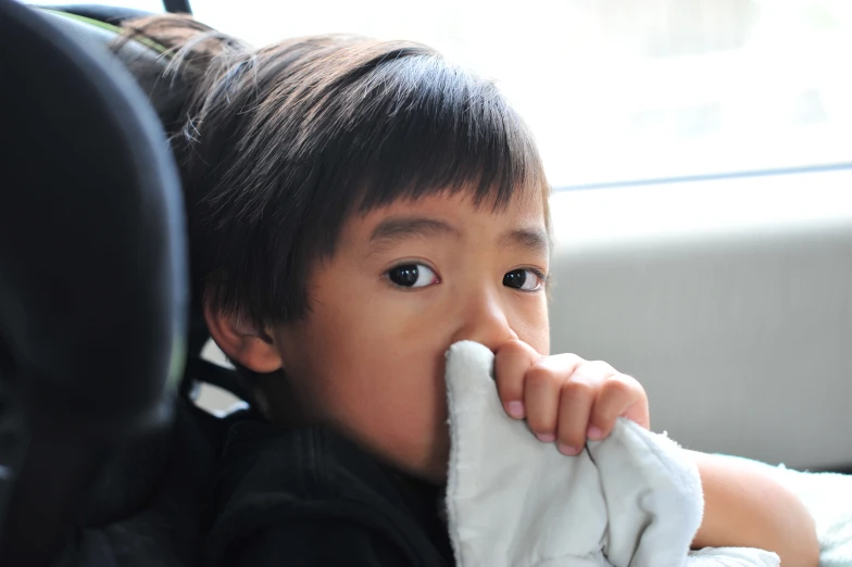 a close up of a child with his hands on the head