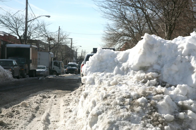 the snow piled up near some buildings on the road