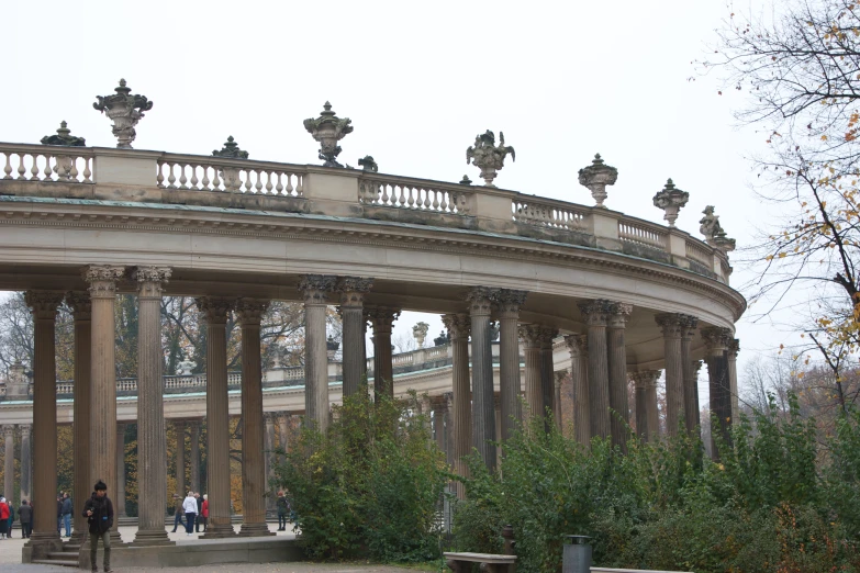 people walking around an ornately designed stone building