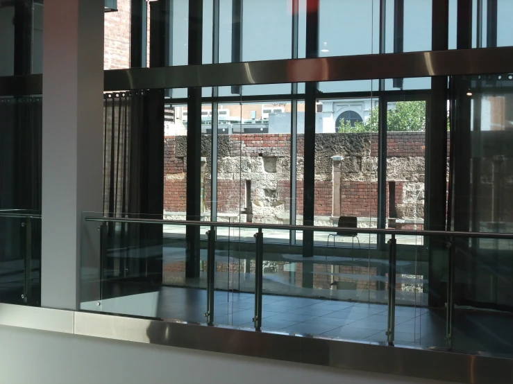 a window reflecting brick building across from a balcony