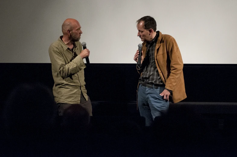 two men holding microphones standing next to each other