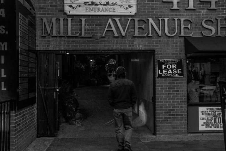 man walking out of a doorway with his hand on the door