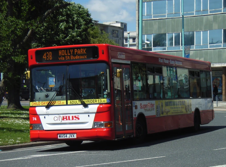 the bus drives down a street in front of tall buildings