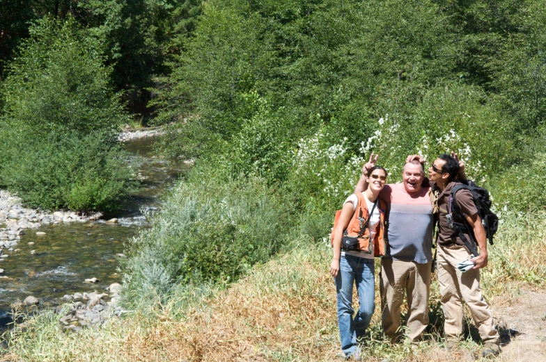 a group of people standing next to each other in front of trees