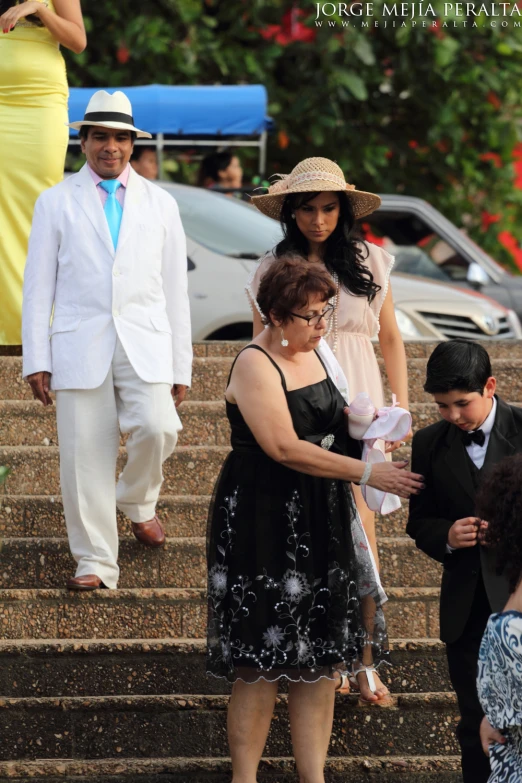 a family standing on steps with one woman holding her infant