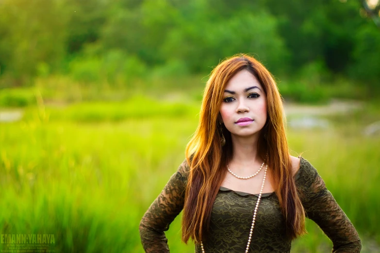 a beautiful red headed woman stands with her hands on her hips