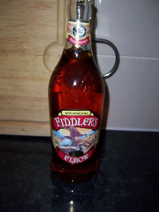 bottle of liquid sitting on counter top with wooden  board