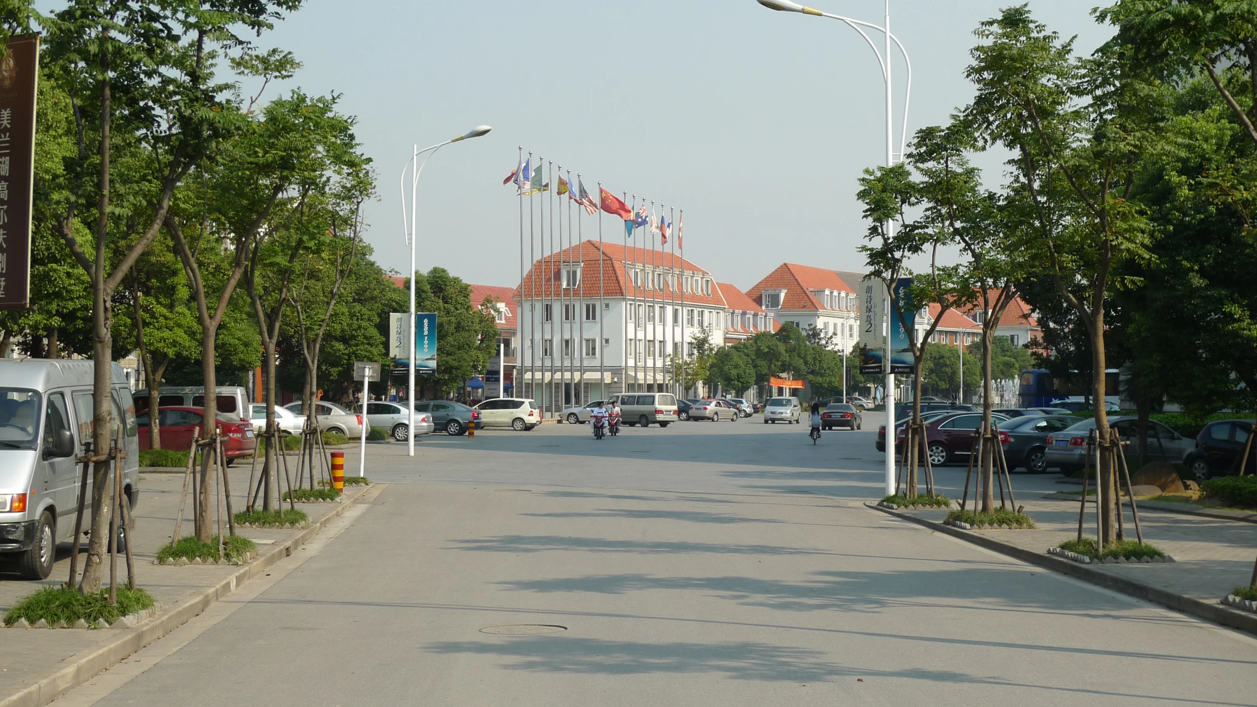 an empty, quiet street with many cars and flags