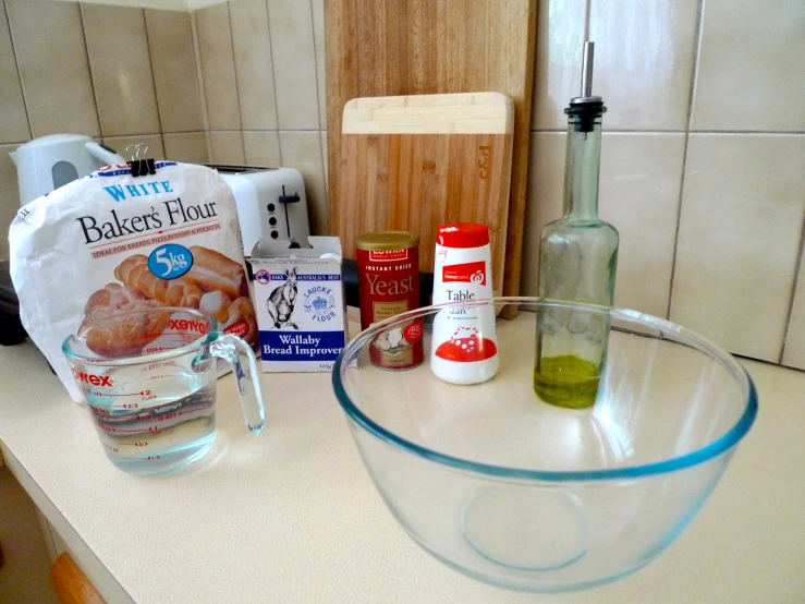 kitchen counter with clear bowls, ingredients and a bread knife