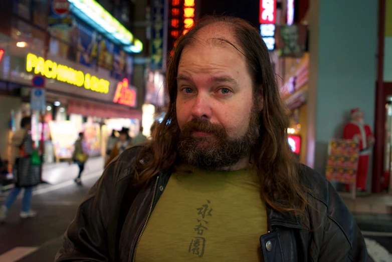 a man with long hair standing in the street