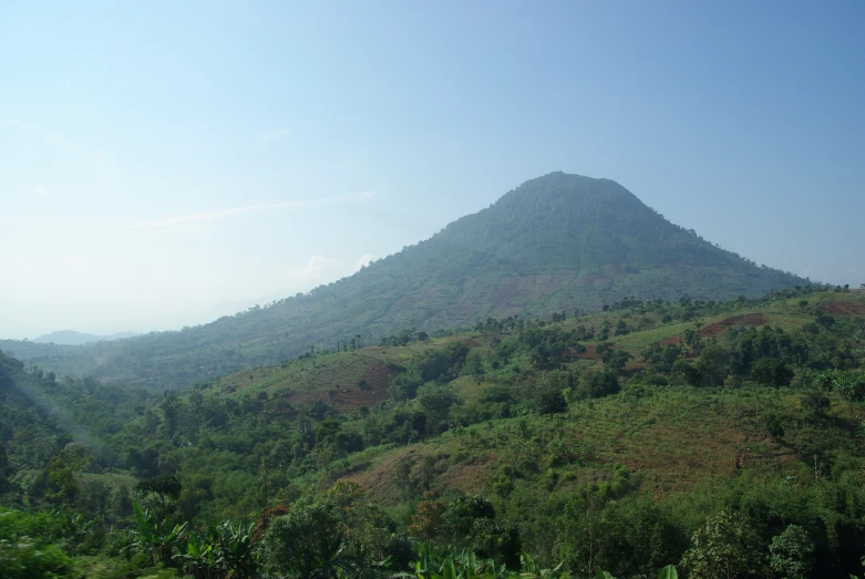 a large mountain with lush green vegetation on the hillside