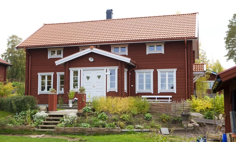 a small brown building with two windows on top of it