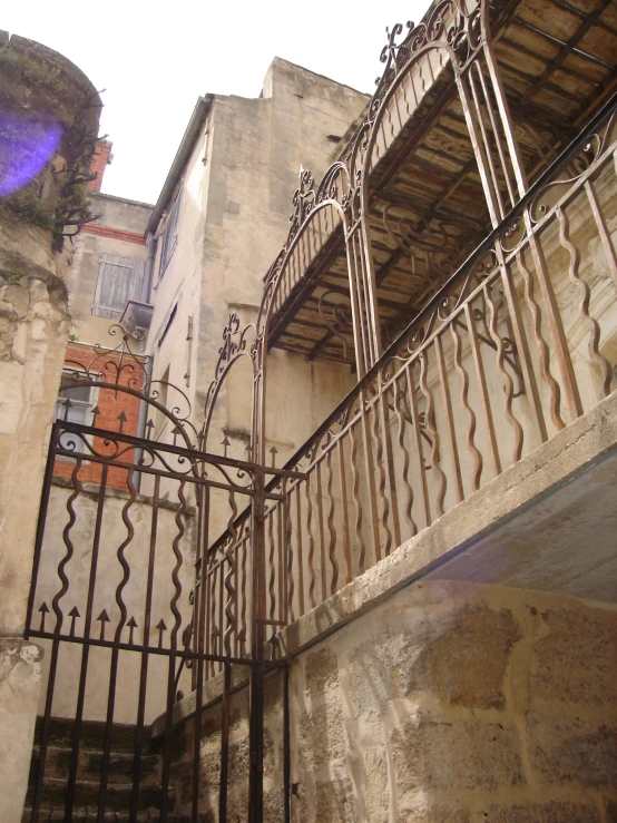 a wrought iron handrail extends out from between two older buildings