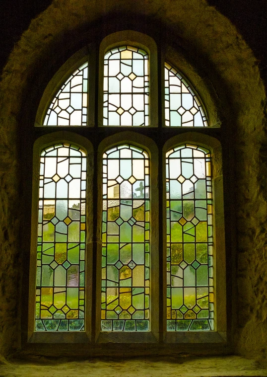 a large stain glass window next to a wooden bench